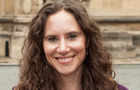 headshot of Eleanor outside a building, smiling to camera