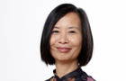 A woman of East Asian descent with a black bob smiles at the camera