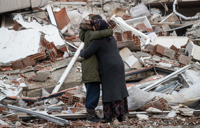  Women hug near a collapsed building in Turkey after one loses her brother in the devastating earthquake