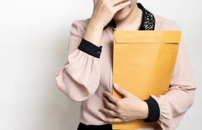 Upset office worker, hand covers face.