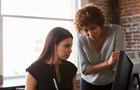 Two Businesswomen Working On Computer In Office