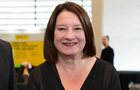 A white woman with a brown bob is smiling at the camera