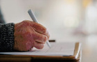 A senior person's hands and signature on will 