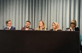 A panel of speakers behind the table 