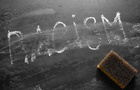 A blackboard with racism written on it