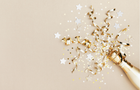 A golden champagne bottle, with confetti stars and party streamers